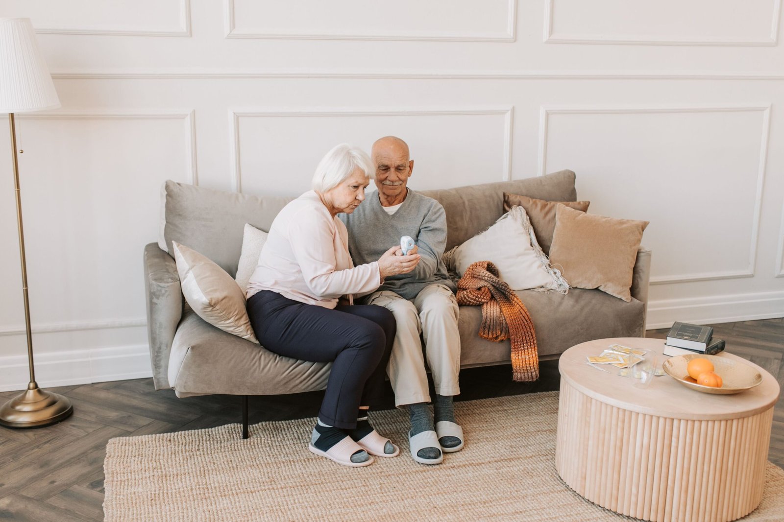 An elderly couple enjoys a relaxing moment together on a sofa in a cozy living room.